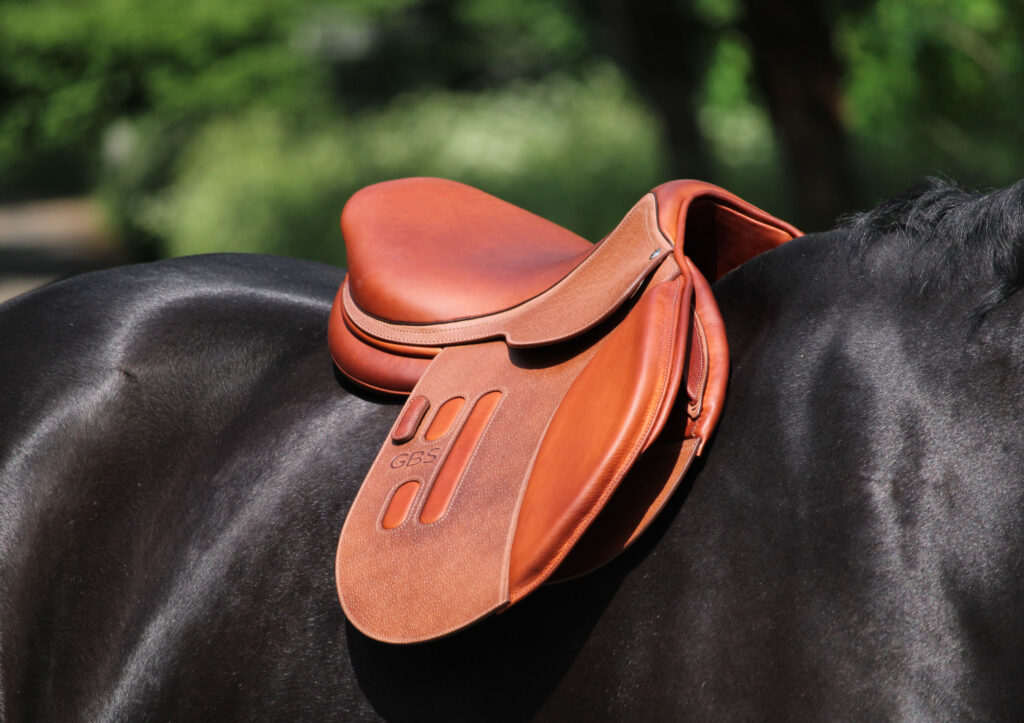 Selle GBS Sellier avec insertion en cuir couleur tabac sur le quartier sur le dos d'un cheval